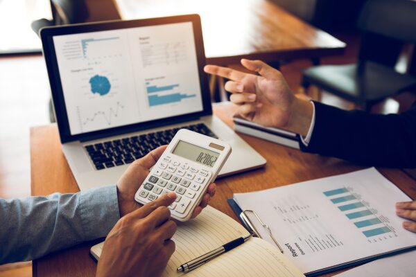 employees with spreadsheets, charts and a calculator